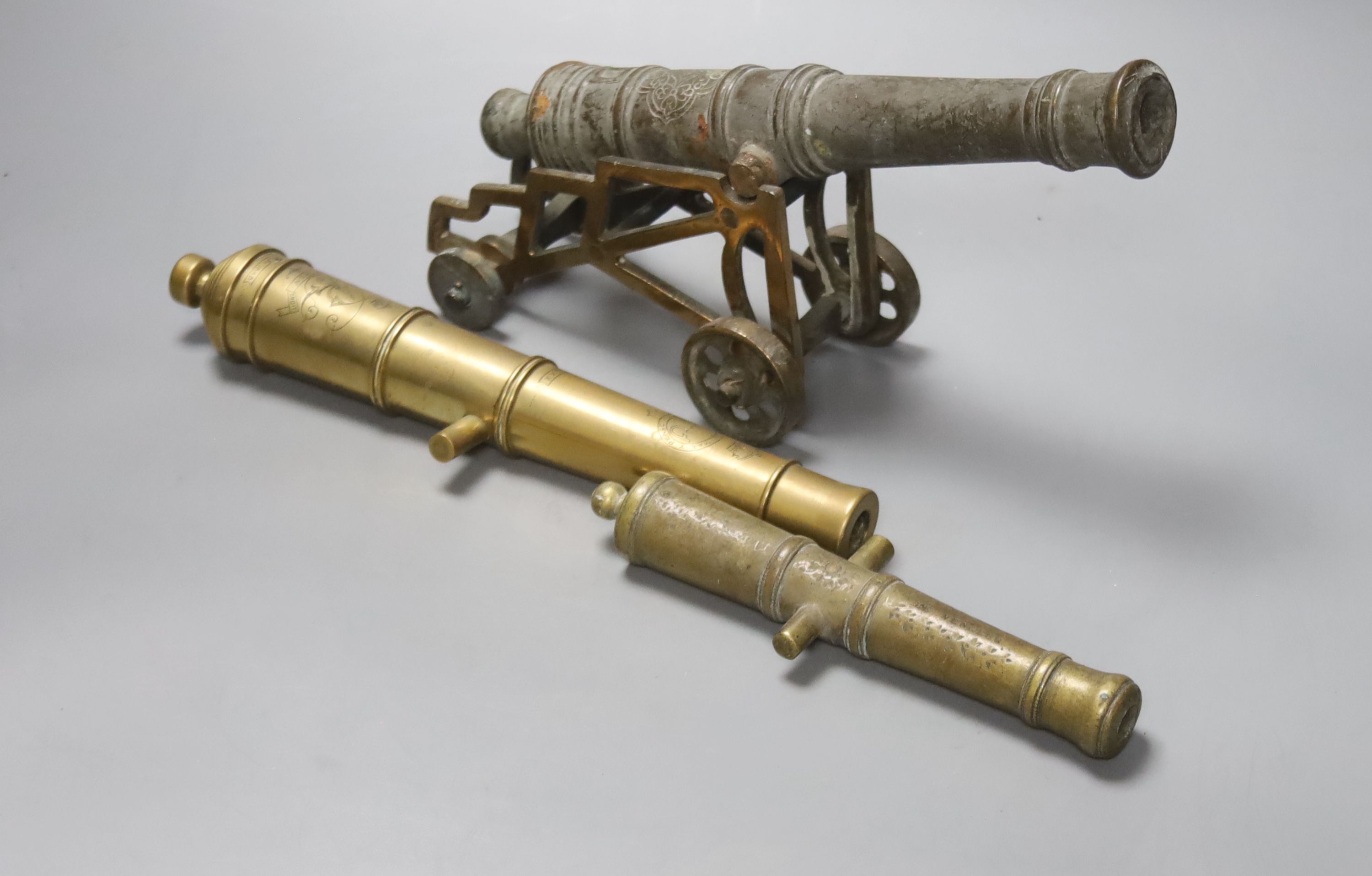 A bronze model cannon engraved  W. North 1848, 25.5cm, a bronze cannon on an associated carriage, 26.5cm, various small brass cannon